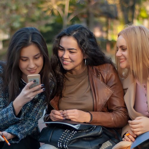 Les femmes souriant et regardent un téléphone